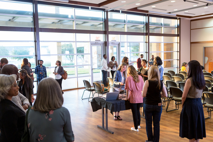 Decorative group of people gathered around a sign in table
