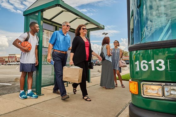 Several people about to board a bus from the bus stop