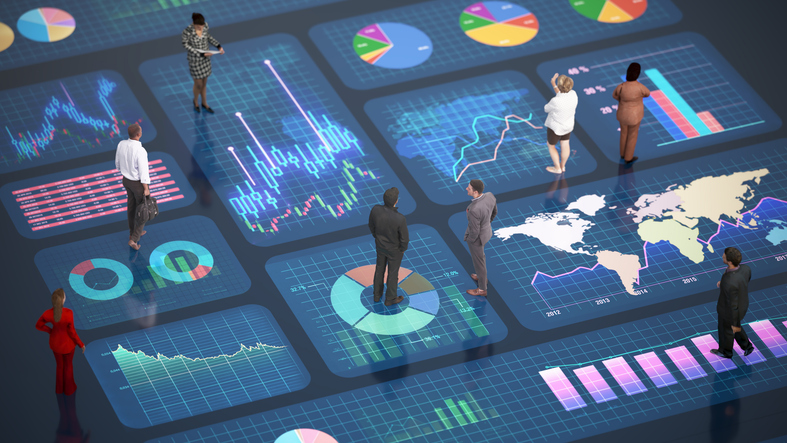 People standing on top of large computer screens with charts and maps