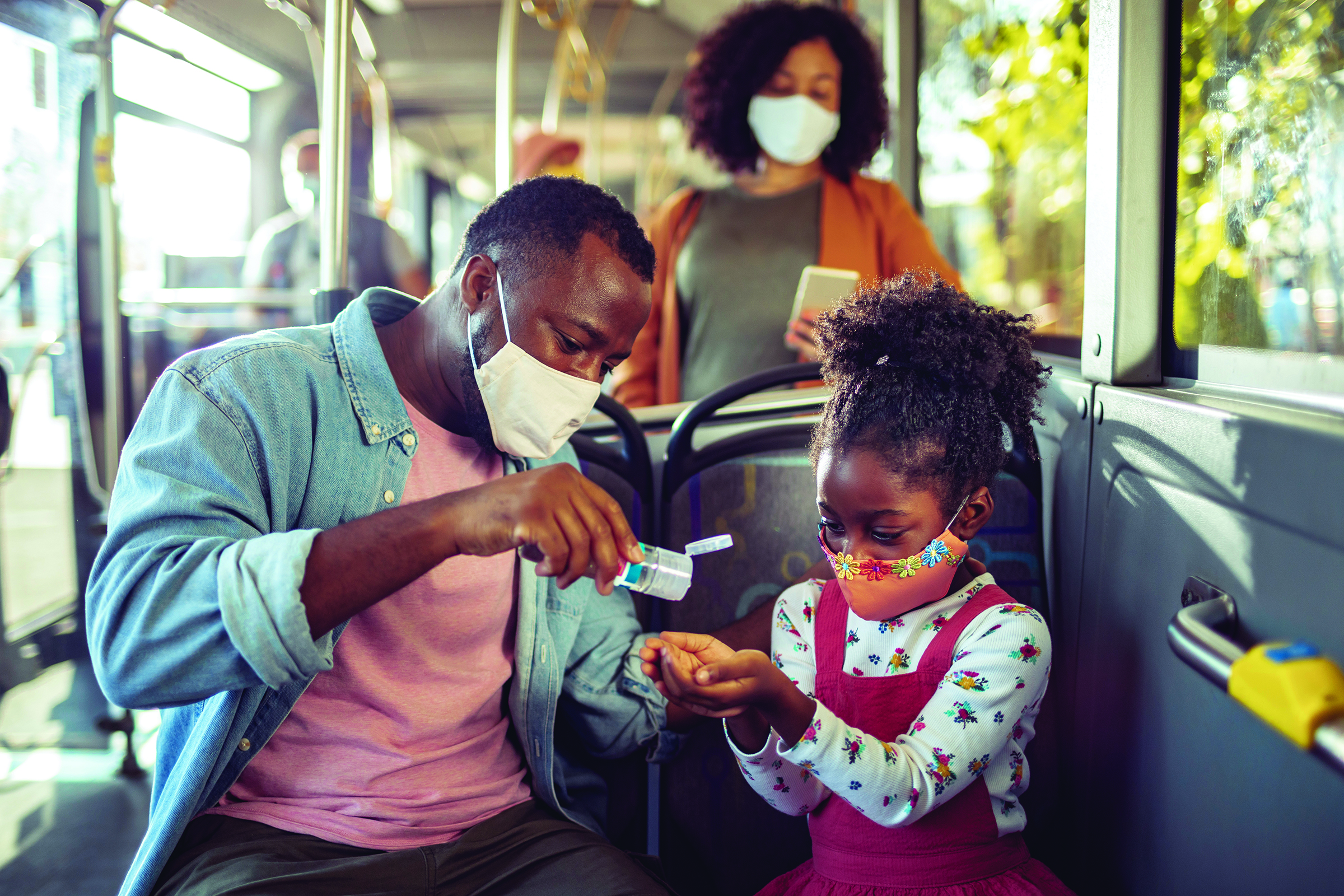 Family wearing masks on a transit vehicle.