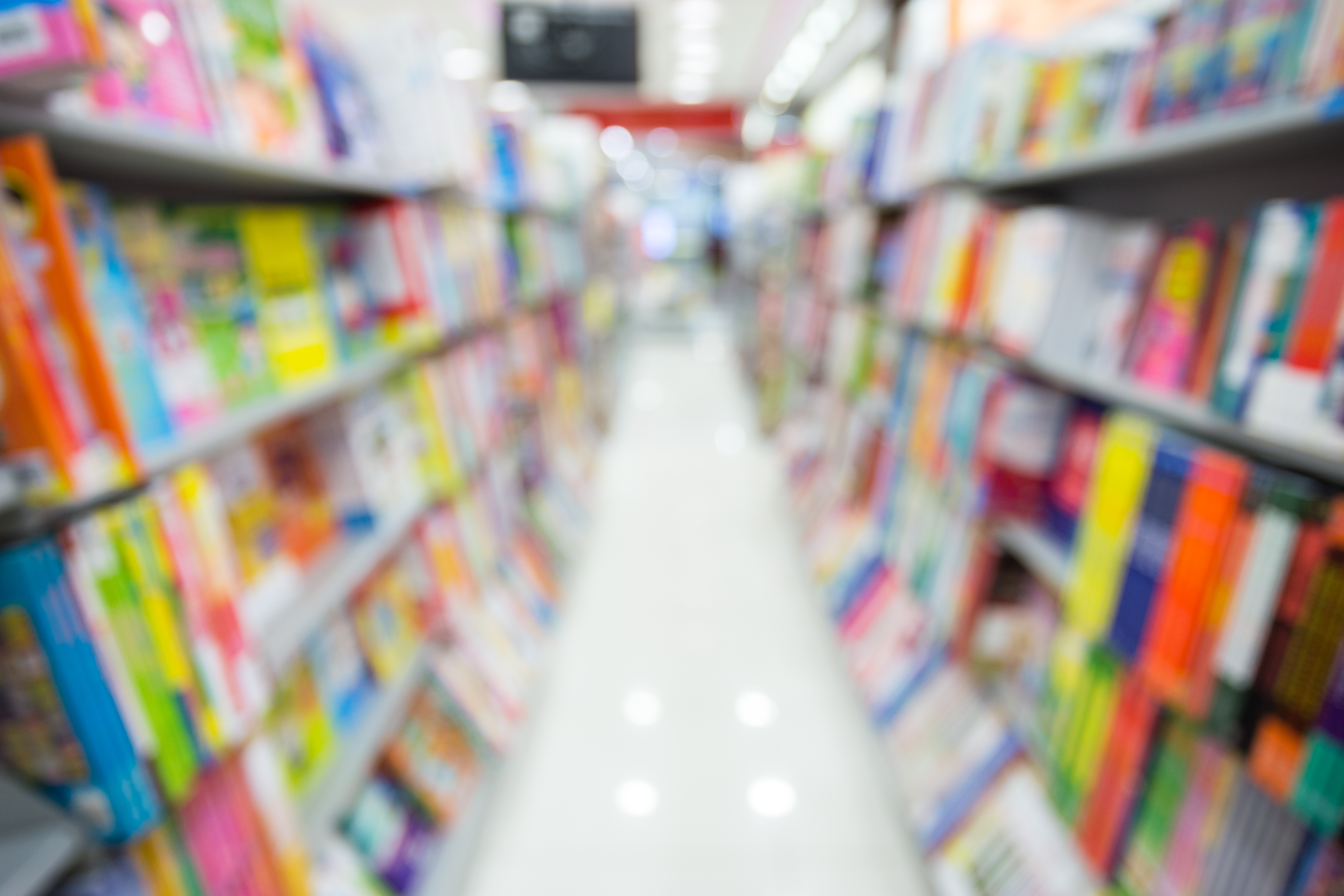 An path between two full library shelves of books